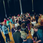 Extraordinary Bodies Creative Explorations workshop in Plymouth - a room full of people dancing, moving and smiling together.
