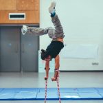 Dergin Tomak dances, balancing on his crutches, with his legs raised up in the air, during an Extraordinary Bodies residency at the National Theatre