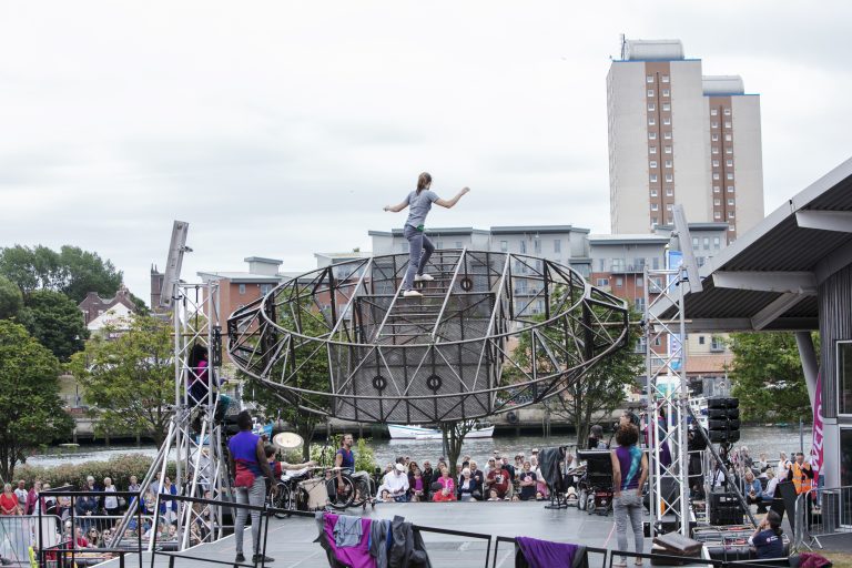 Extraordinary Bodies, What Am I Worth? performance shot from Sunderland 2018: As the structure spins, Aislinn is climbing and balancing a top the set.