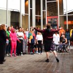 A diverse choir rehearse in front of the National Theatre, London.