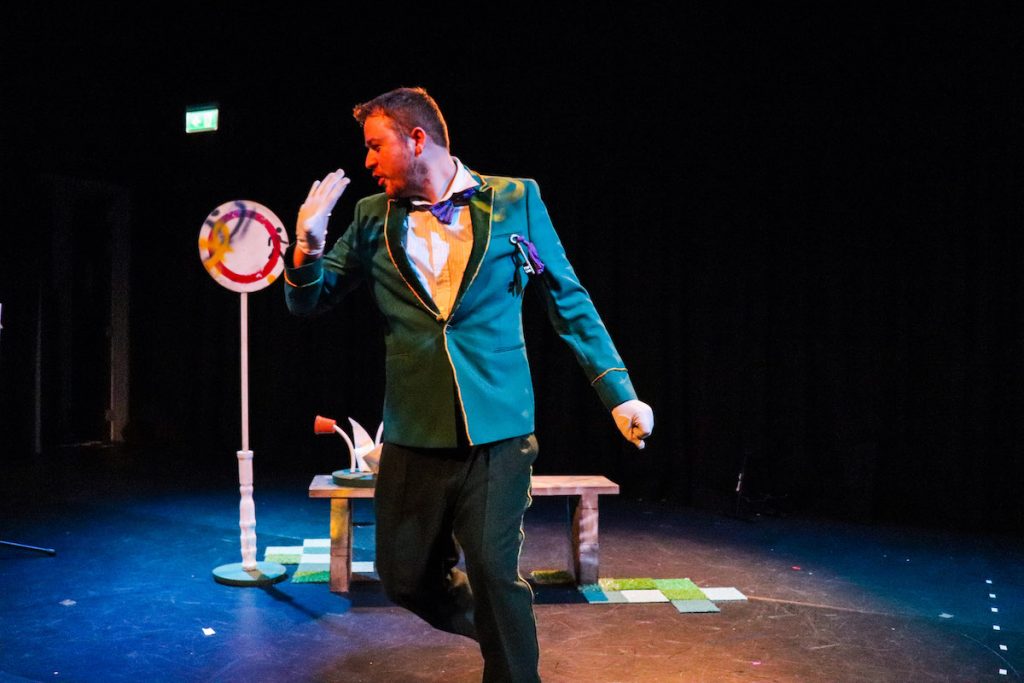 Extraordinary Bodies Young Artists perform Till We Win at Lighthouse Poole - Shane Masterman dancing centre stage, in a dapper suit and white gloves.