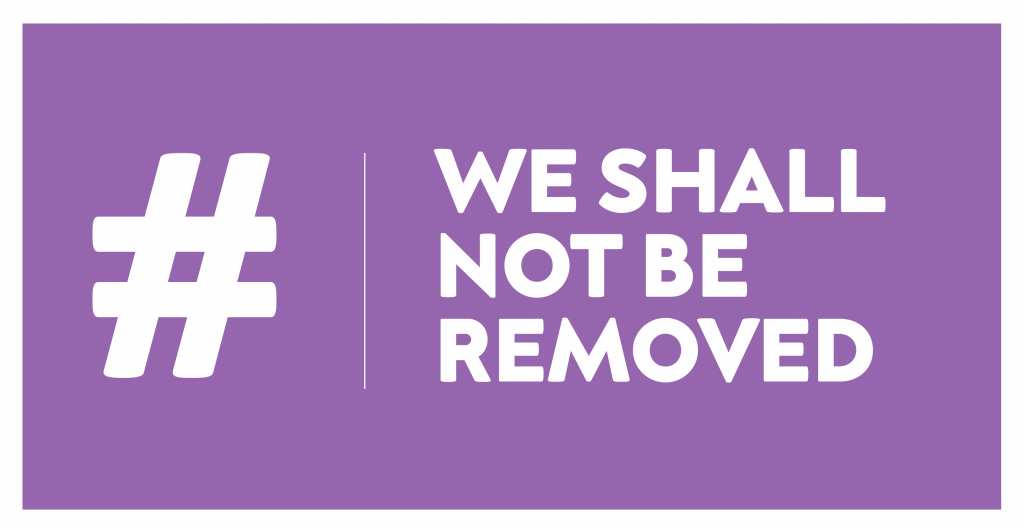 "#WeShallNotBeRemoved" written in bold capital letters on a purple background.