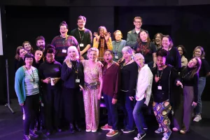 Mid Life creative team and cast all looking towards the camera making funny faces and laughing.
