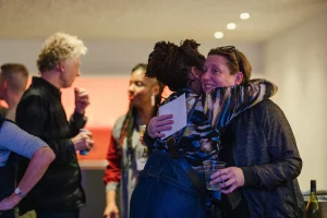 Laura and Jacqui hugging after a Mid Life show in the centre of the picture.