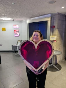 Producer Laura Dickens holding the Human Heart smiling to the camera.