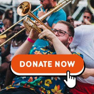 Harry Bassett playing trumpet in a band with a bright colourful shirt on.